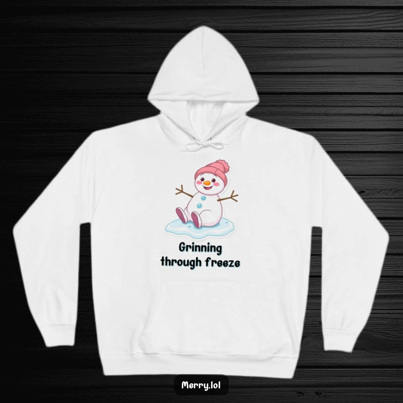 Funny hoodie depicting a grinning snowman character comically slipping on ice, radiating winter cheer and amusement.
